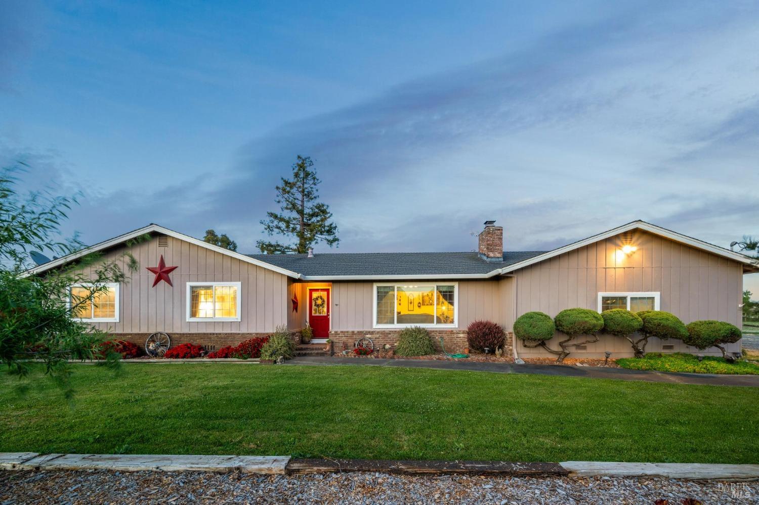 Sonoma Valley ranch home at dusk with warm lights glowing through the windows
